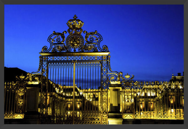 Golden gate to Versaille against a twilight sky.
